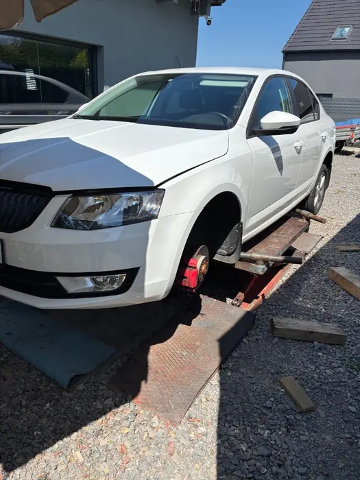 Servis bílé Škody se sejmutým kolem